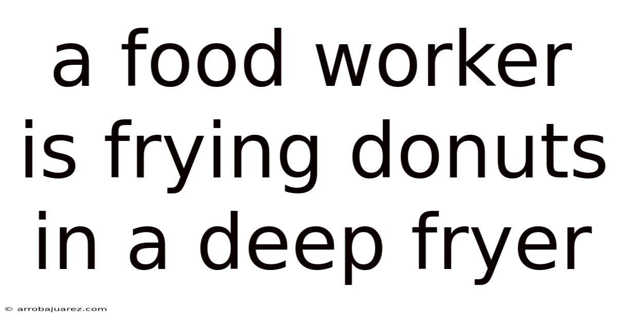 A Food Worker Is Frying Donuts In A Deep Fryer